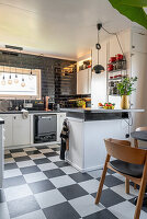 Black and white kitchen with linoleum floor in chequered pattern
