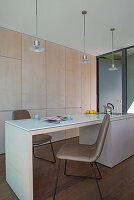 Kitchen island with dining and cooking area in front of light-colored built-in cabinets