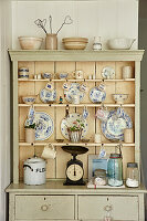 Dishes, vintage scale and storage jars on sideboard