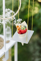 Fruits in paper bags on a hanging shelf