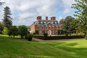 View across lawn to 17th century red brick country house
