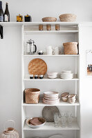 Kitchen shelf with beige-brown stoneware against a white wall
