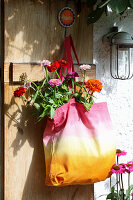 Colorful DIY fabric bag with dahlias on a wooden door