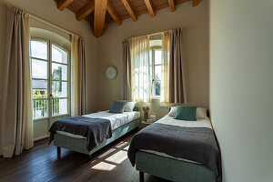 Two single beds in a room with a wooden ceiling