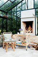 Rattan furniture and open fireplace in a glass house
