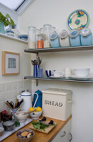Vorratsdosen auf Regalen in kleinem weißen Küchenanbau mit Emaille-Brotkasten aus den 50er-Jahren