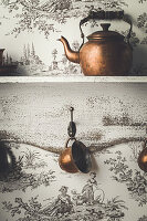 Kettle and tea cups in front of Toile-de-jouy wallpaper