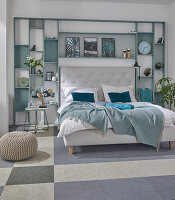 Double bed with headboard against a wall of shelves