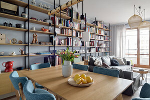 Living room with dining area, seating area and floor-to-ceiling shelving unit