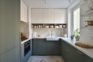 U-shaped fitted kitchen in sage green and cream colours