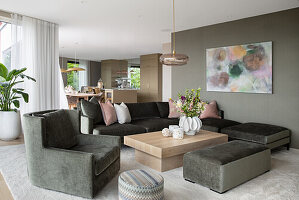 Grey sofa set, coffee table and large-format painting on the wall in the open-plan living room
