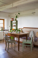 Table with wooden chairs and bench seating in country kitchen