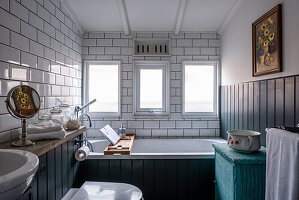 Underground tiles and wood panelling in the bathroom of a converted Victorian railway carriage
