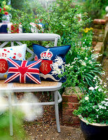 Garden bench decorated with cushions for the coronation of King Charles III, UK