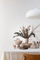 Set table with bouquet of eucalyptus, brooms, and dried poppies and shell decoration