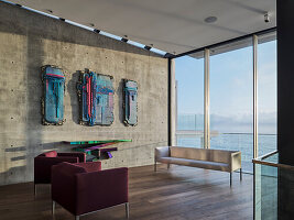 Lounge mit moderner Kunst an Betonwand und Meerblick