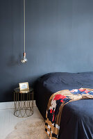 Modern bedroom with dark blue wall and gold accents