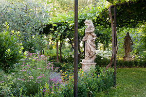 Statues in the garden and vine-covered pergola