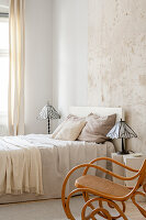 Schlafzimmer mit Schaukelstuhl und Bett im minimalistischen Stil
