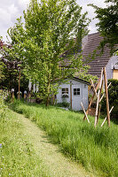 Garden shed with tall grasses and trees in the garden