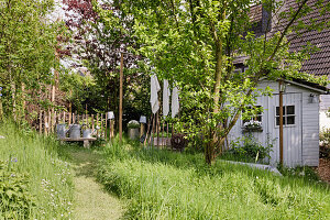 Idyllischer Garten mit Gartenhaus im Sommer