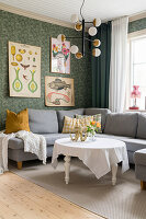 Graue Sofaecke mit rundem Couchtisch und Retro-Wandbildern