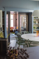 Dining room with round table, passageway to living room with yellow and blue sofa