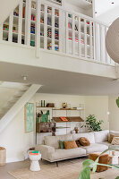 Bright living room with corner sofa, a gallery and bookshelves