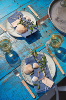 Griechisch gedeckter Tisch mit Olivenzweigen und Muscheln