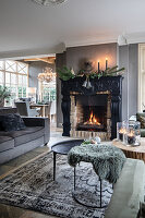 Open-plan living area with dark fireplace and set dining table in the background