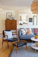 Open-plan living room with mid-century furniture, grey sofa and woven hanging lamp