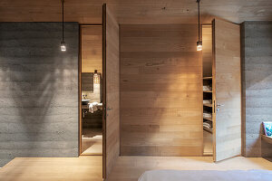 Modern bedroom with concrete wall and wooden elements