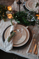 Festively laid table with linen napkins, candles and eucalyptus branches