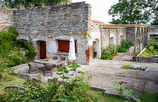 Cosy garden area in front of stone building with several seating areas