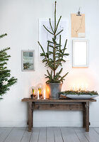 Wooden table with Advent decorations, candles and Christmas tree in a zinc bucket