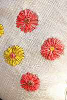 Embroidered cushion with floral motifs in red and yellow