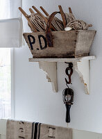 Wooden basket with spools of thread on a rustic wall shelf