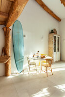 Small dining area with surfboard and rustic wooden beams