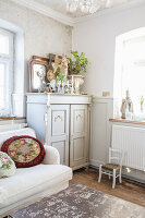 Shabby chic living room with antique cupboard and vintage decorations