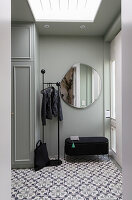 Hallway with mirror, coat rack and patterned floor tiles