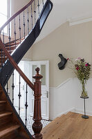 Entrance area with wooden staircase and bouquet of flowers