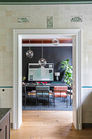 Dining room with black walls, modern chairs and hanging glass globe lights