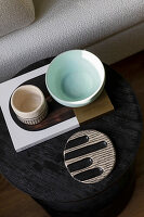 Round side table with ceramic bowls and book