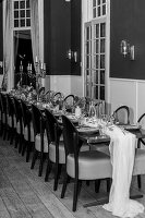 Gedeckter Tisch für eine Feier in einem eleganten Raum mit Holzboden