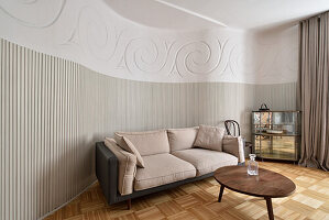 Living room with herringbone parquet flooring and curved relief wall