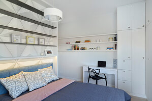 Modern bedroom with integrated workstation and shelving wall