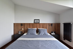 Schlafzimmer mit Holzkopfteil und eingebauten Nachttischen