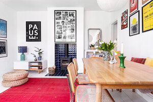 Dining area with wooden table, red carpet and lots of pictures