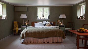 Bedroom with double bed and green plastered walls