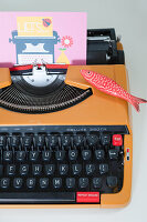 Retro typewriter with greeting card and fish decoration